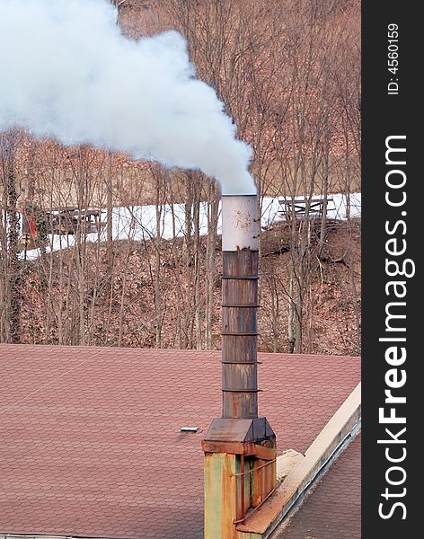 Toxic smoke rising from a chimney in a natural ambient. Toxic smoke rising from a chimney in a natural ambient