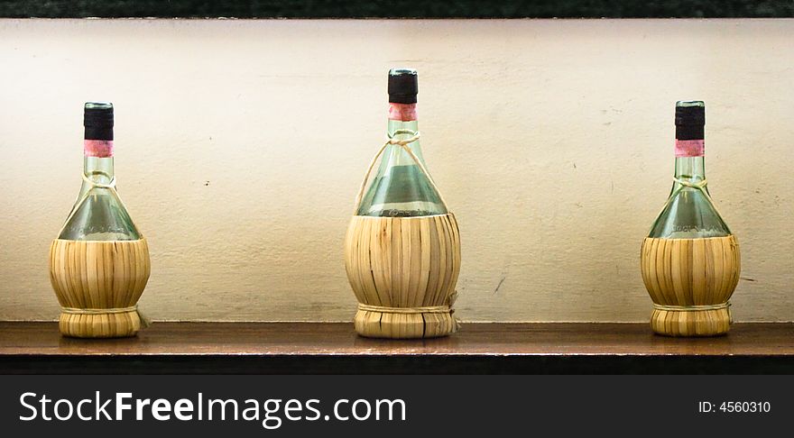 Three tipical italian wine bottles with straw covering. Three tipical italian wine bottles with straw covering