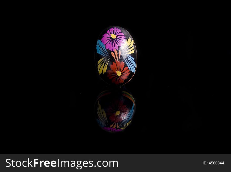 Easter egg on black mirror, hand painted - isolated