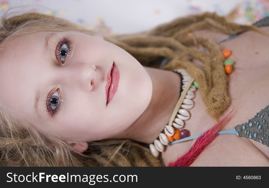 A pretty blond girl with dreads laying on the floor, surrounded by candies. A pretty blond girl with dreads laying on the floor, surrounded by candies