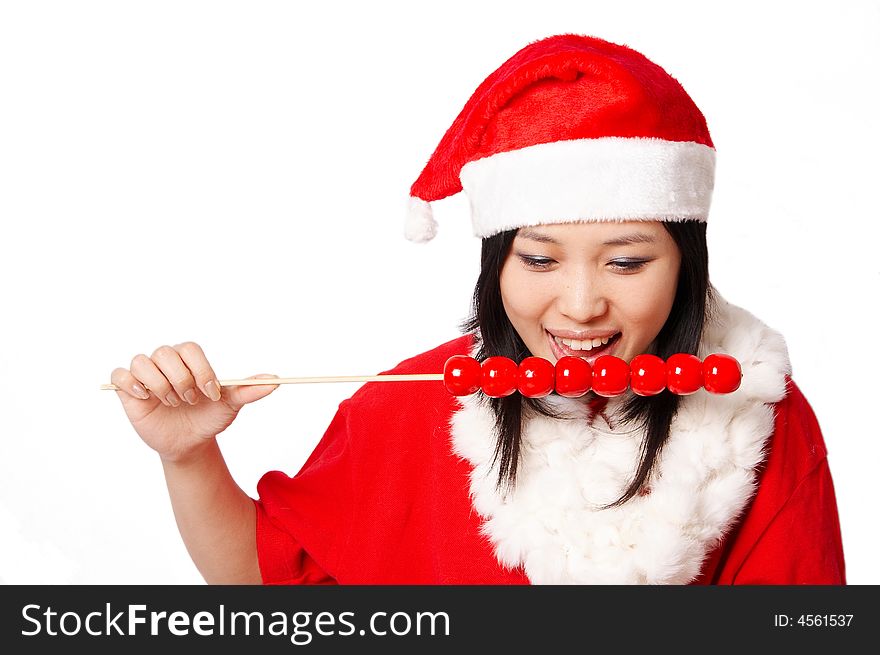 Beautiful asian Santa Claus girl smiling and eating chinese traditional food Tanghulu isolated on white. Beautiful asian Santa Claus girl smiling and eating chinese traditional food Tanghulu isolated on white