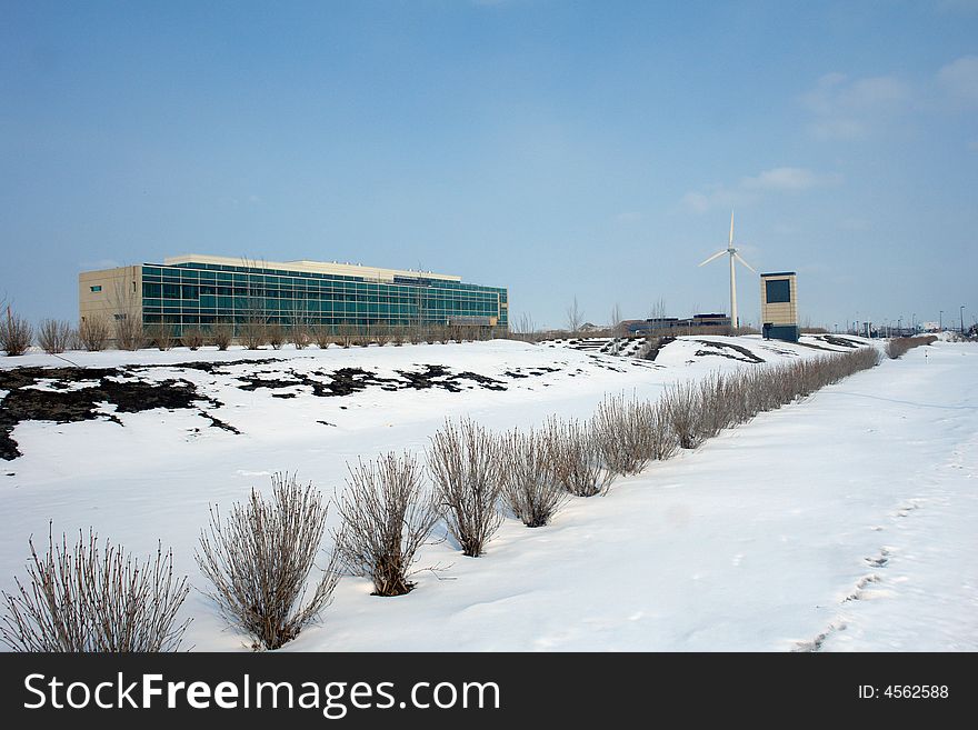 A picture of a wintry landscape with corporate building  and distant windmill