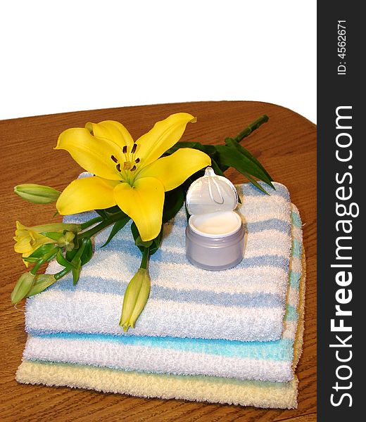Towels, yellow flower, and cream, as a concept of beauty, massage and alternative medicine.