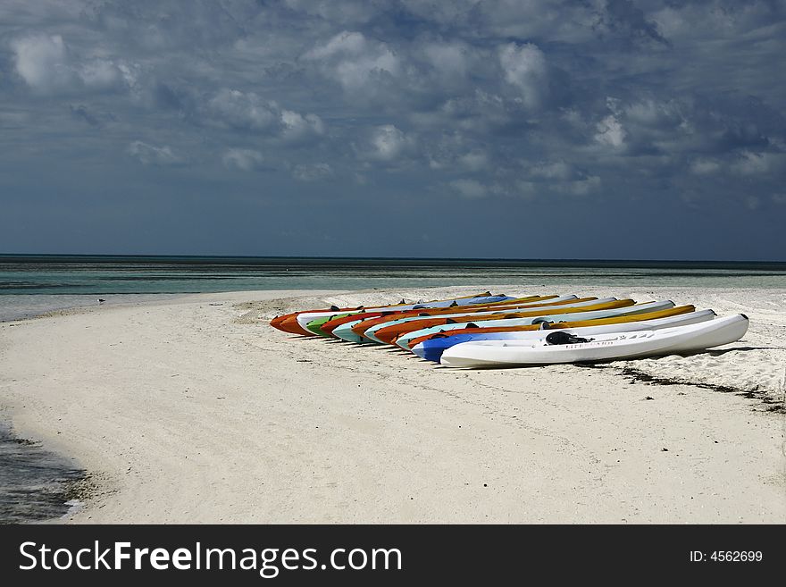 Kayaks lined up on beautiful tropical beach. Kayaks lined up on beautiful tropical beach
