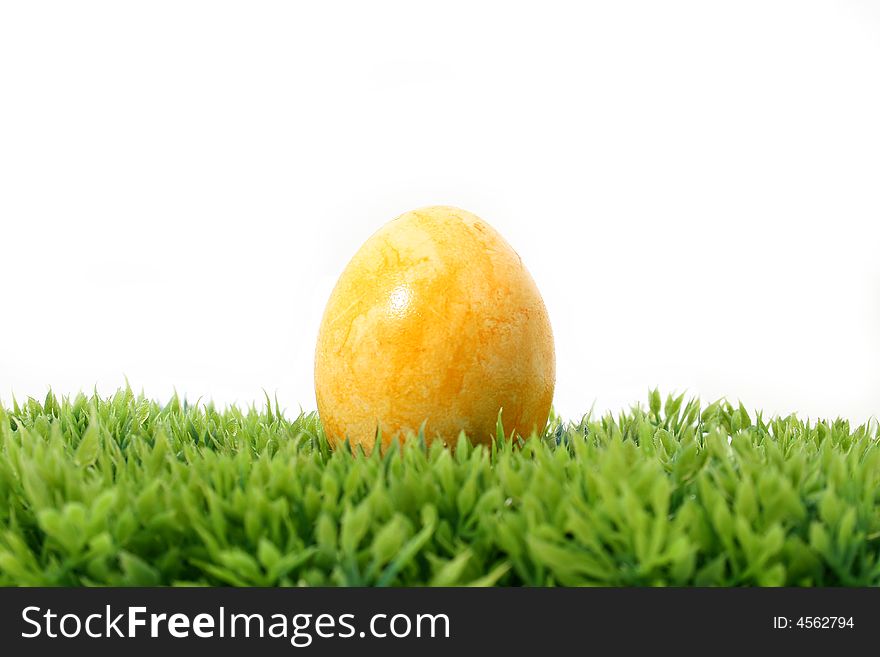 A yellow easter egg on grass