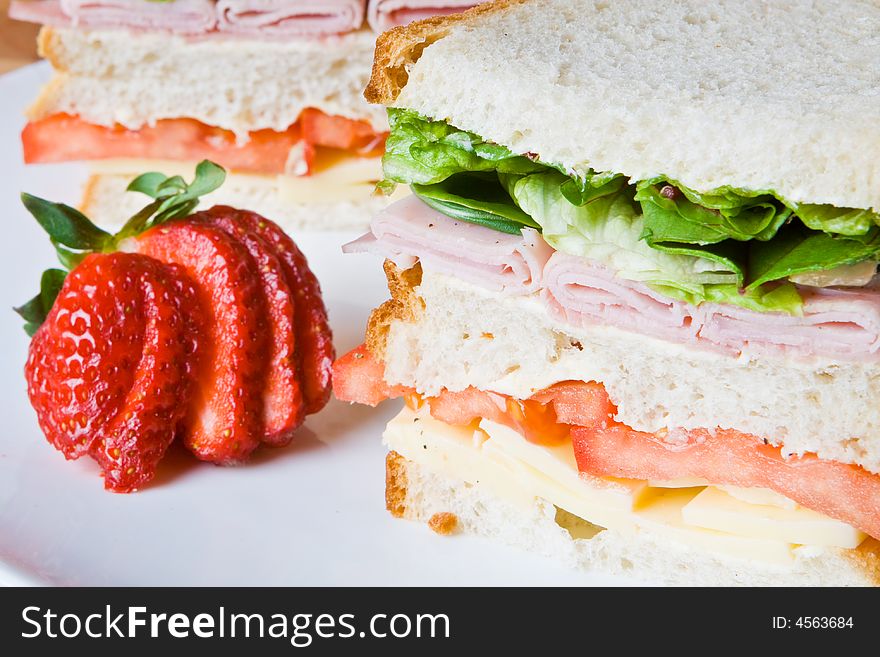 Ham, cheese and tomato sandwich with a fresh strawberry