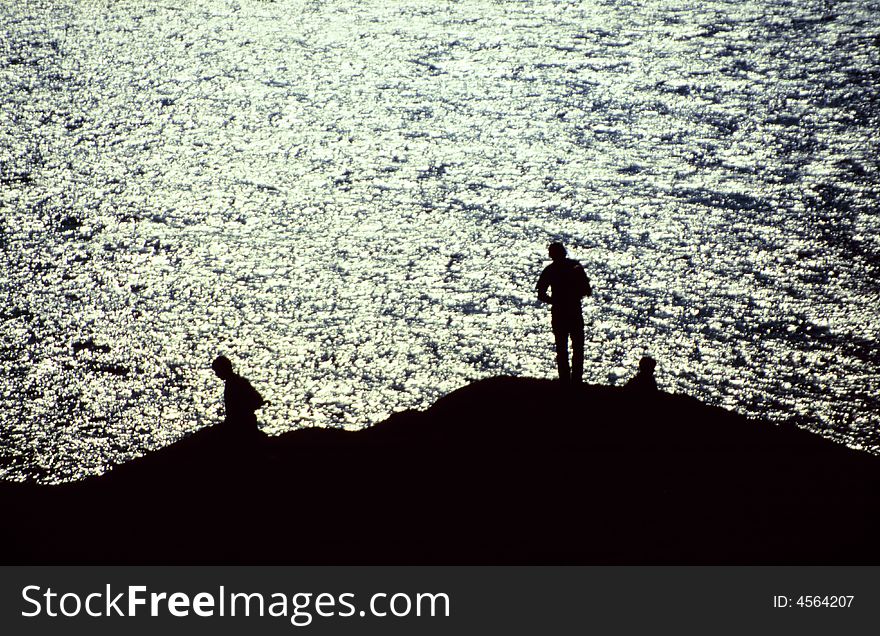 Silhouettes of fishermen by the sea