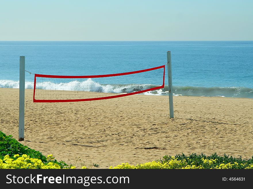 A beach volleyball net on the beach at the ocean. A beach volleyball net on the beach at the ocean