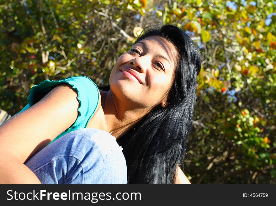 Woman smiling with green trees in background