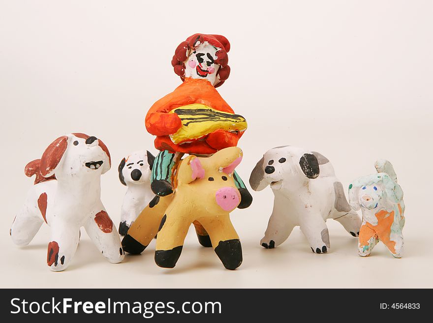 Painted clay figures of a balalaika player on pig and four dogs. Painted clay figures of a balalaika player on pig and four dogs