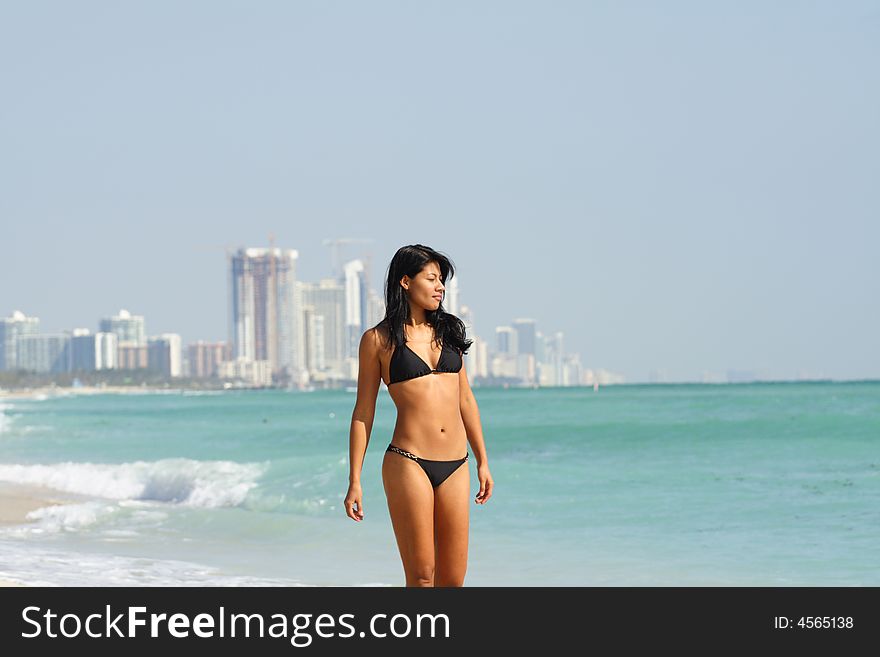 Woman walking near the ocean shore. Woman walking near the ocean shore.