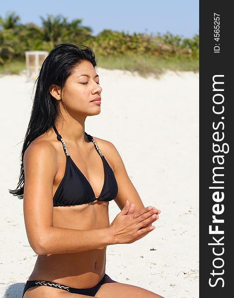 Beautiful young woman on the beach doing yoga exercises. Beautiful young woman on the beach doing yoga exercises.