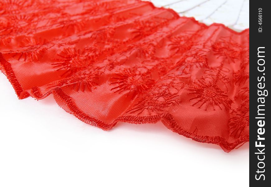 Part of red fan lying on white surface. Abstract red and white background. Part of red fan lying on white surface. Abstract red and white background.