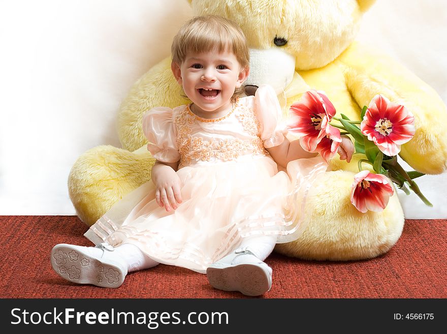 Cute little girl with tulips and teddy bear