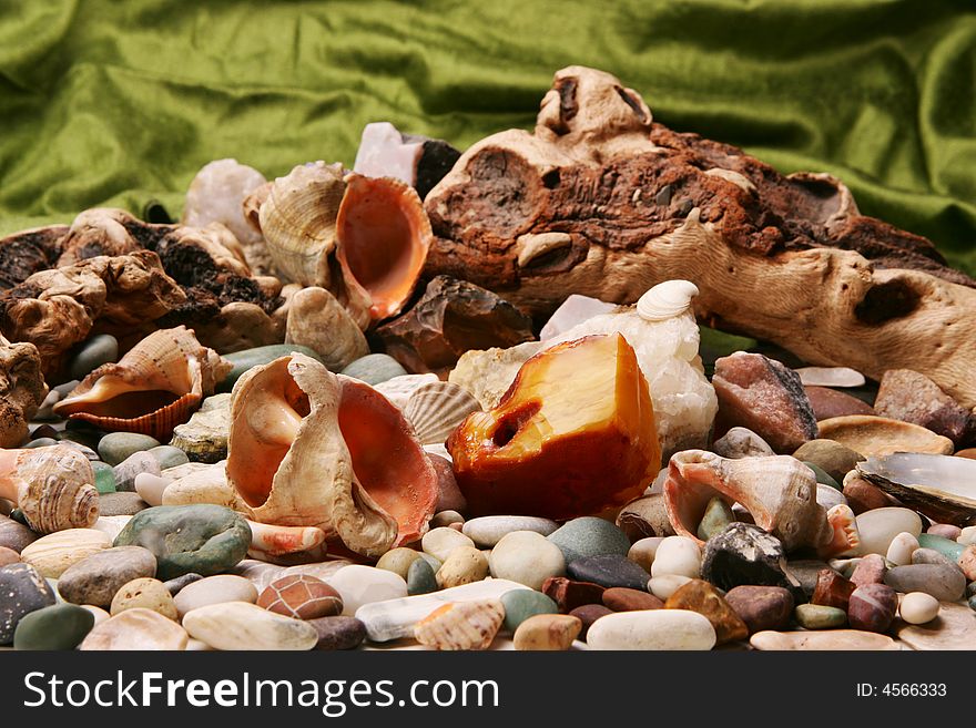 A piece of rugged amber on the stone beach amidst seashells. A piece of rugged amber on the stone beach amidst seashells