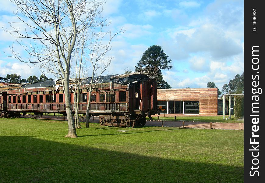 Old and oxide train wagon in the countryside, with the sky background