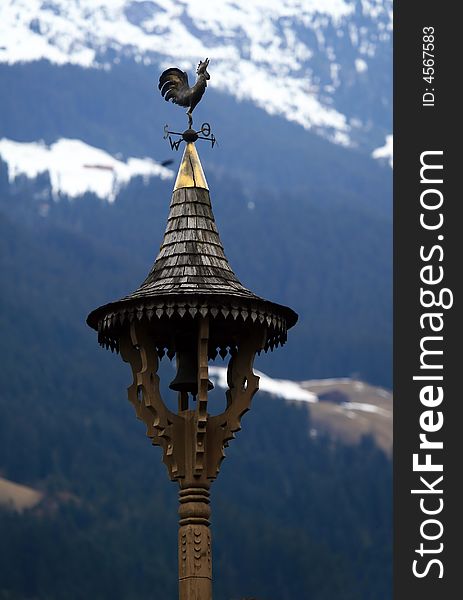 Golden weather vane on the roof in Tirol. Golden weather vane on the roof in Tirol