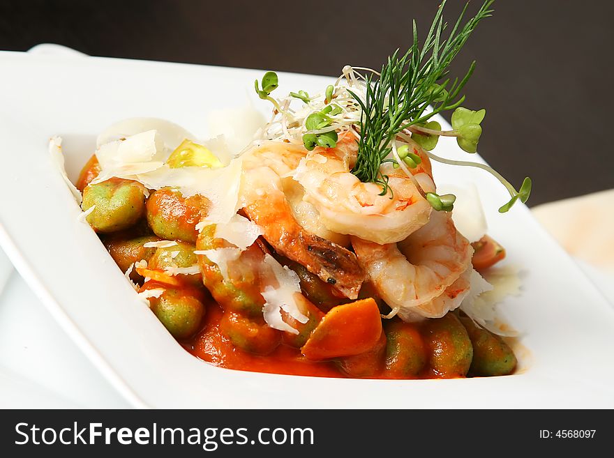 Four shrimps with caper and artichoke on the table