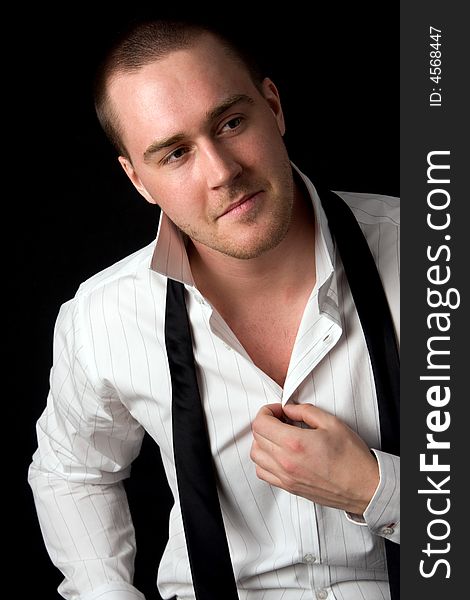 Portrait of a young businessman on black background