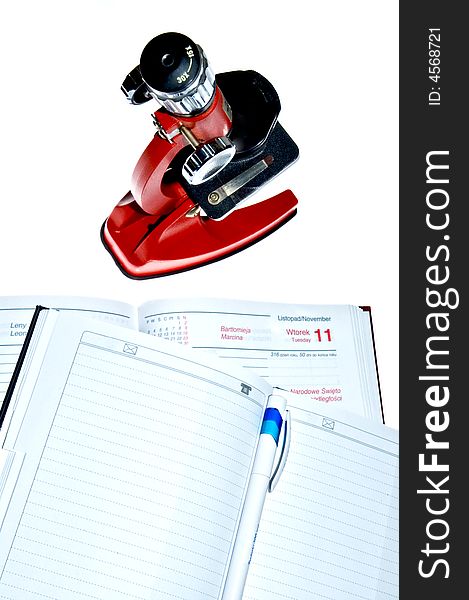Microscope and notes over white background