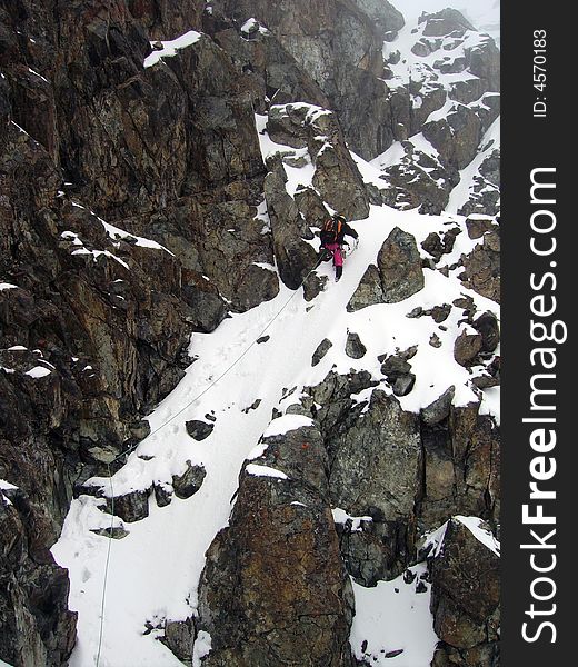 Alpinist climbing in mountains on mixed route. Alpinist climbing in mountains on mixed route