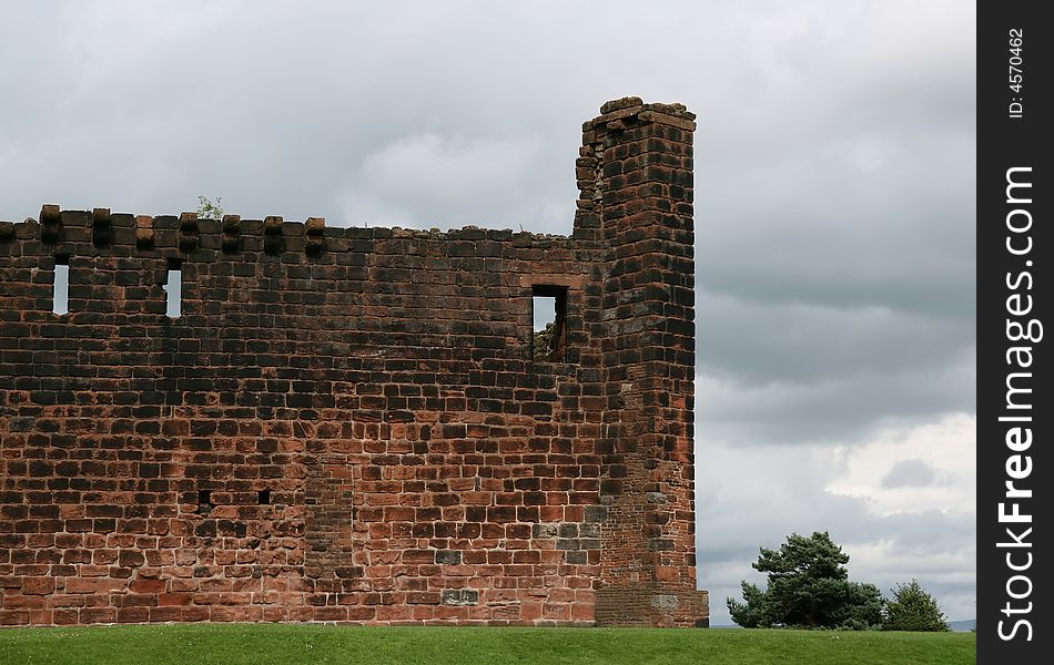 A section of a castle ruin wall with moody sky. A section of a castle ruin wall with moody sky