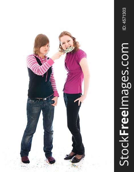 The two girls with a sugar candy isolated on a white background