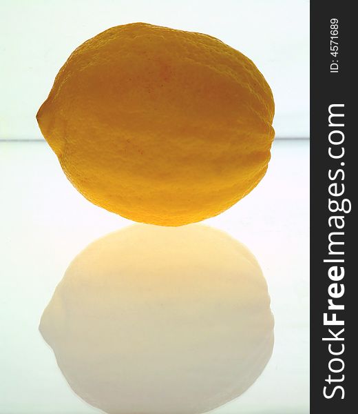 Close-up of a rough-skinned lemon with its reflection.