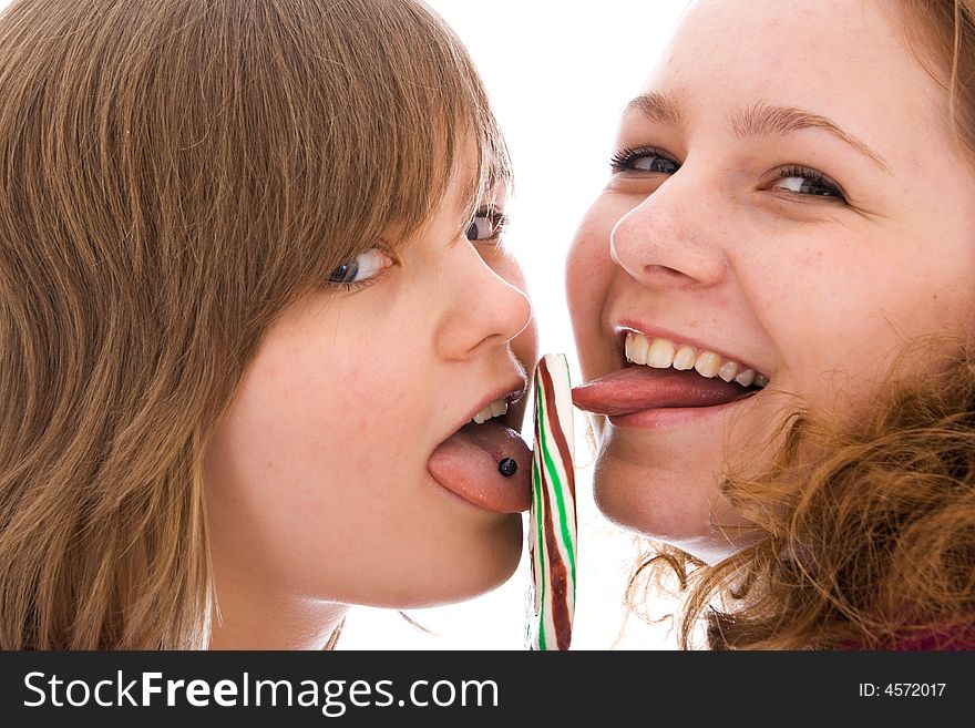 The two girls with a sugar candy isolated on a white background
