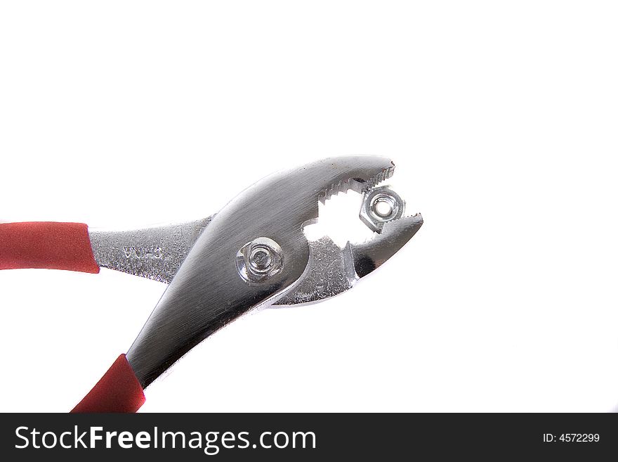 A pair of pliers gripping a hex nut against a white background. A pair of pliers gripping a hex nut against a white background