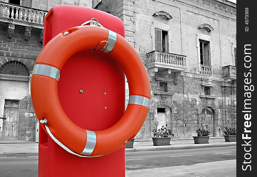 A life bouy in front of an old building.