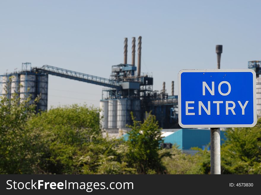 No entry sign with an industrial scene in the background