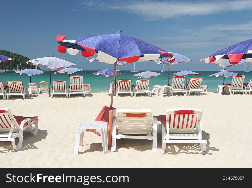 Rows of colorful beach chairs and umbrellas at the beach.