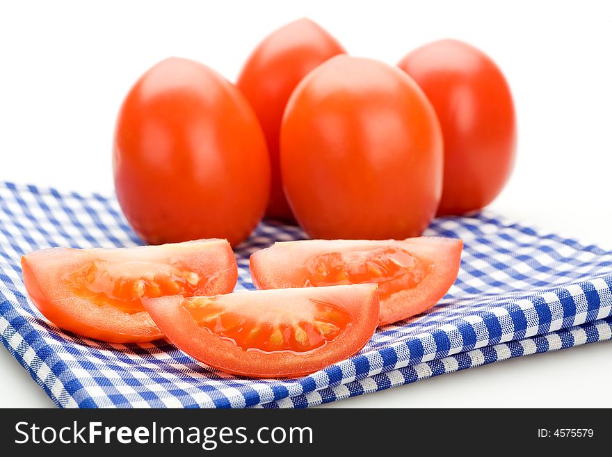 Red tomatoes on a blue cloth, isolated on white background