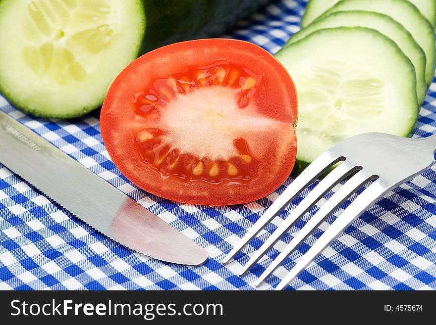 Tomato and cucumber on checked blue background