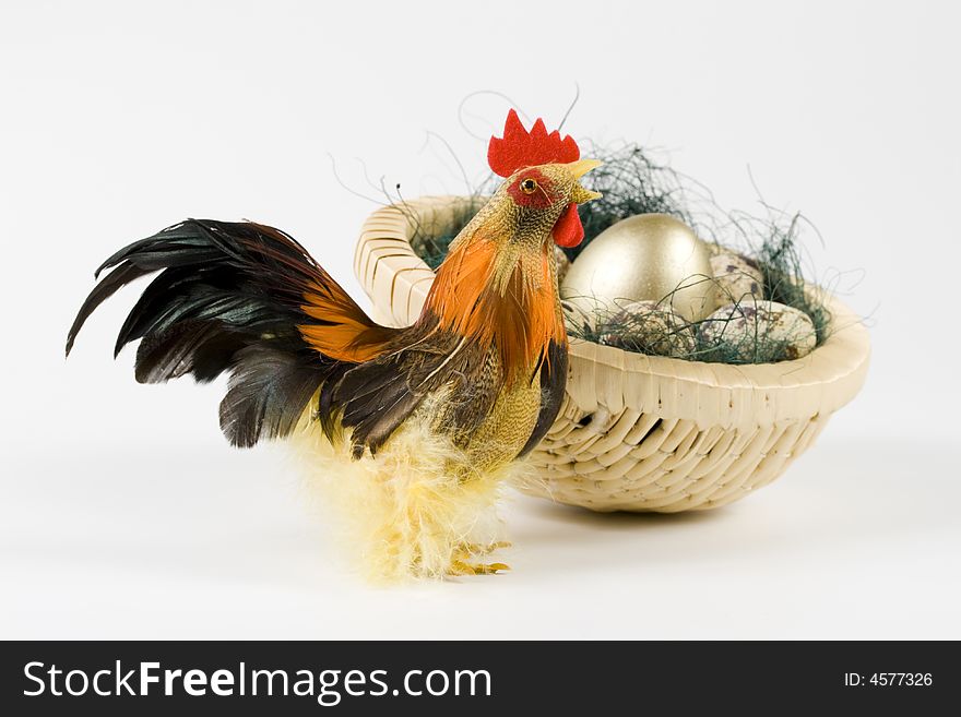 Cock and eggs and gold egg in a nest on a white background. Cock and eggs and gold egg in a nest on a white background