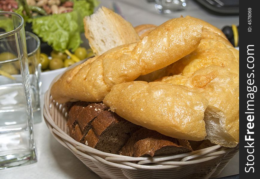 Pieces of different sort of bread and Italian chiabatta in biscuit dish on the served table