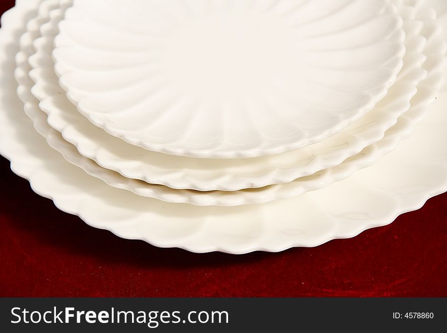 A shot of white plates isolated on red