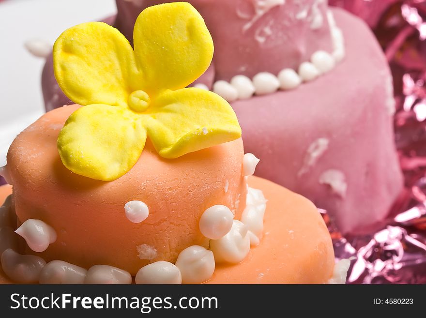 Two small nicely decorated cakes yellow and pink