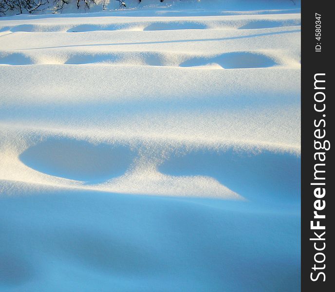 Foot prints in the snow with shadows on a snowy day in winter after a storm in wisconsin