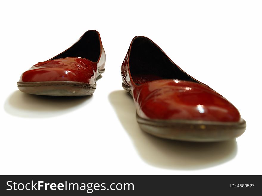 A pair of red glossy shoes. A pair of red glossy shoes