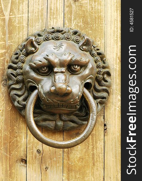 An ancient knocker withe a figure of lion. In ancient China, this kind of knocker were used on door for visitors to knock the door. It is made with some tigerish animal, which means it can deter the trespassers.