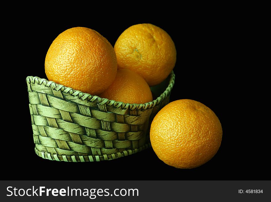 Basket with oranges on a black background