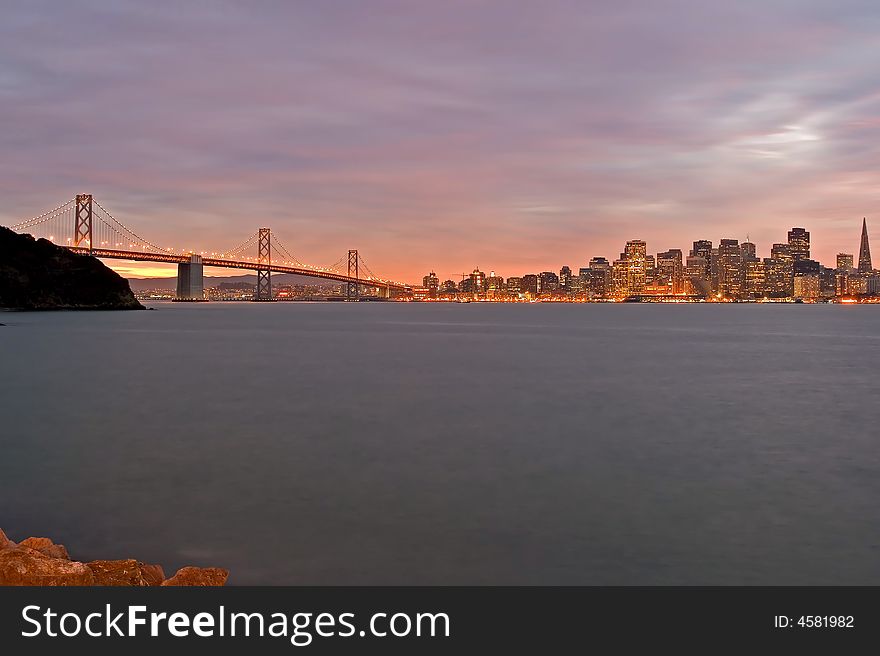 San Francisco and Bay Bridge at night with Christmas lights around the buildings