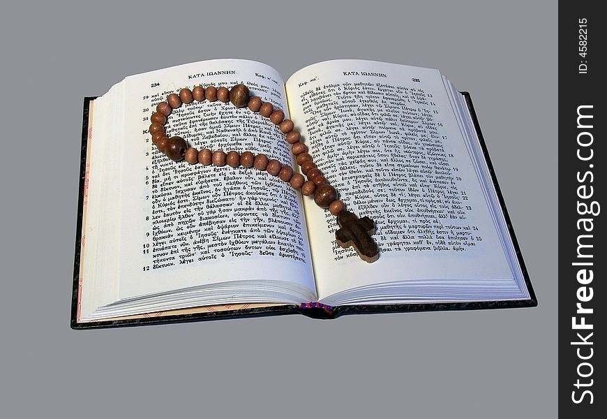 Little wooden rosary lying on open religious book. Little wooden rosary lying on open religious book