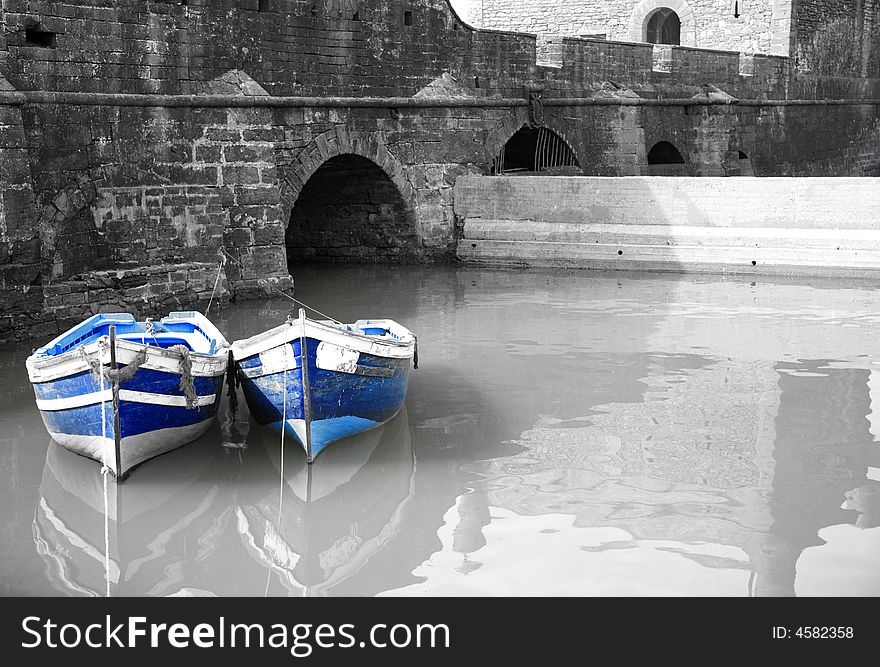 Black and white harbour with two blue boats Essaouria Morocco