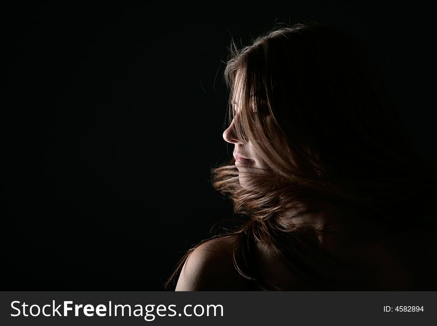 Young woman portrait on the wind with black background