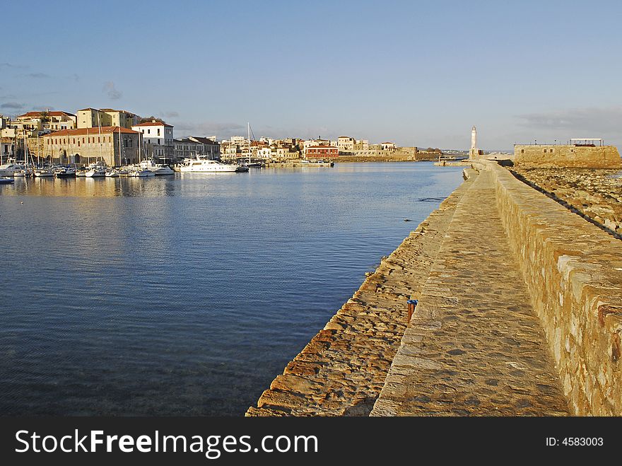 Walkway on the wallthat lead to the light tower in the venetian harbour of Chania, crete. Walkway on the wallthat lead to the light tower in the venetian harbour of Chania, crete.