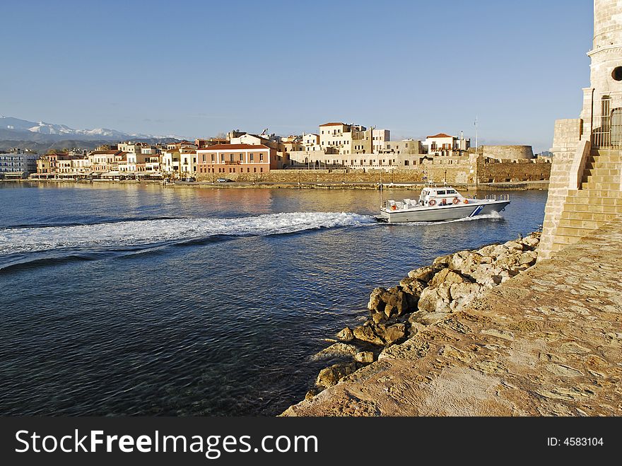 The guardboat leaving the venetian harbour of chania in the morning. The guardboat leaving the venetian harbour of chania in the morning