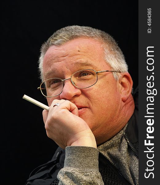 Man with glasses holding a cigarette and looking dreamy. Man with glasses holding a cigarette and looking dreamy